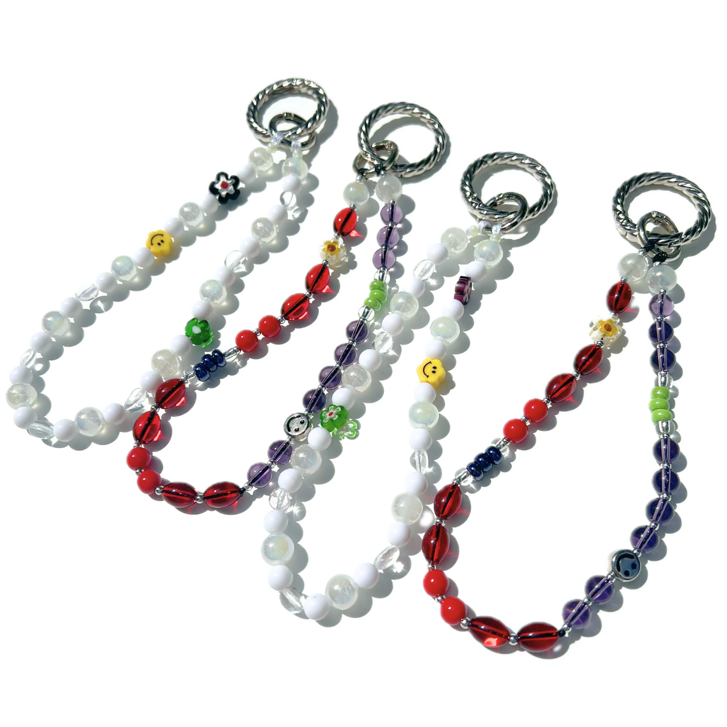 Set of eclectic beaded charms from Sweet Kiri featuring cherry red, purple, and white beads with smiley and floral details, each finished with a silver twist clasp. Handmade with glass, Czech, millefiori, and acrylic beads.