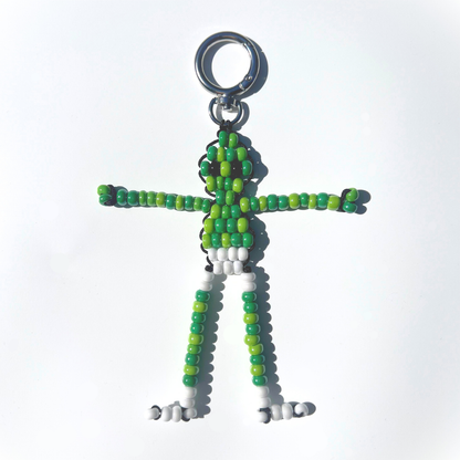 Front view of a handmade Beaded Green Martian Bag Charm featuring glossy green and white beads, silver-tone ring clasp, and playful alien design.