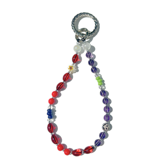 Cherry red and purple eclectic beaded charm with daisy detail, chrome smiley bead, and twist clasp, handmade with glass, Czech, millefiori, and acrylic beads.