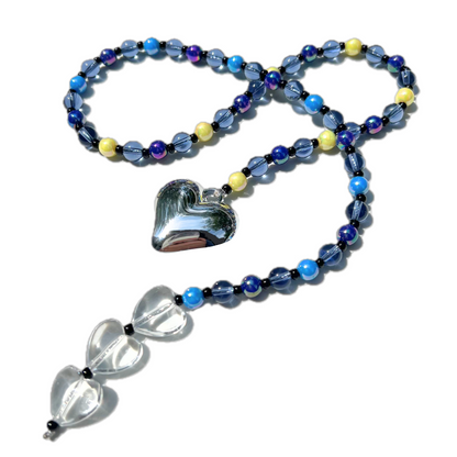 Close-up detail of the Chrome Silver Heart Bag Charm highlighting the reflective chrome silver heart pendant, midnight blue beads, and translucent clear crystal hearts.