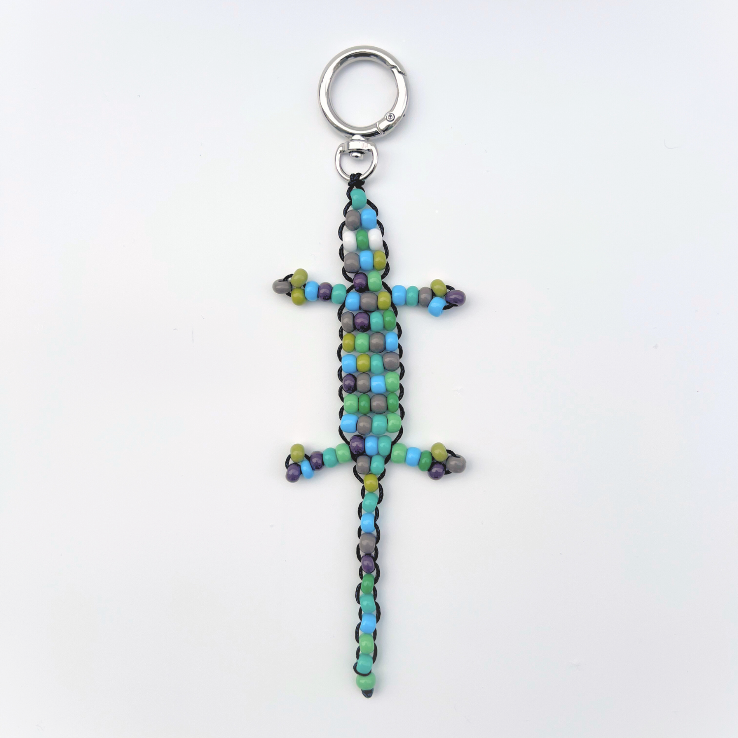 Single green, blue, and grey beaded gecko bag charm photographed front-facing on a white background with metal keyring.