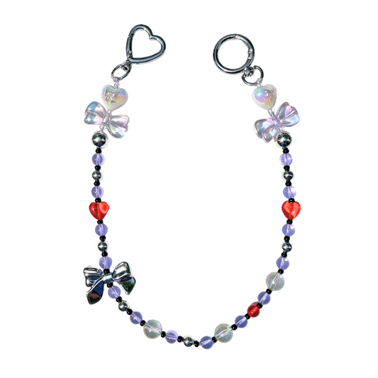 Handmade lilac beaded charm with iridescent bow beads, red heart accents, and chrome accents in a magical girl style.