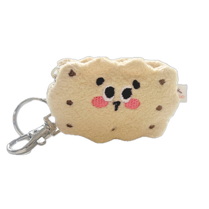 Kawaii vanilla sandwich cookie plush keychain with embroidered face, pink cheeks, and chocolate chip details, attached to silver keyring.