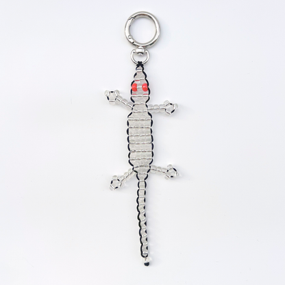 Single silver beaded gecko bag charm with red eyes, photographed front-facing on a white background with metal keyring.