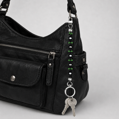 Handmade black daisy beaded bag charm clipped to black leather handbag – elegant multi-use keychain for designer and everyday bags