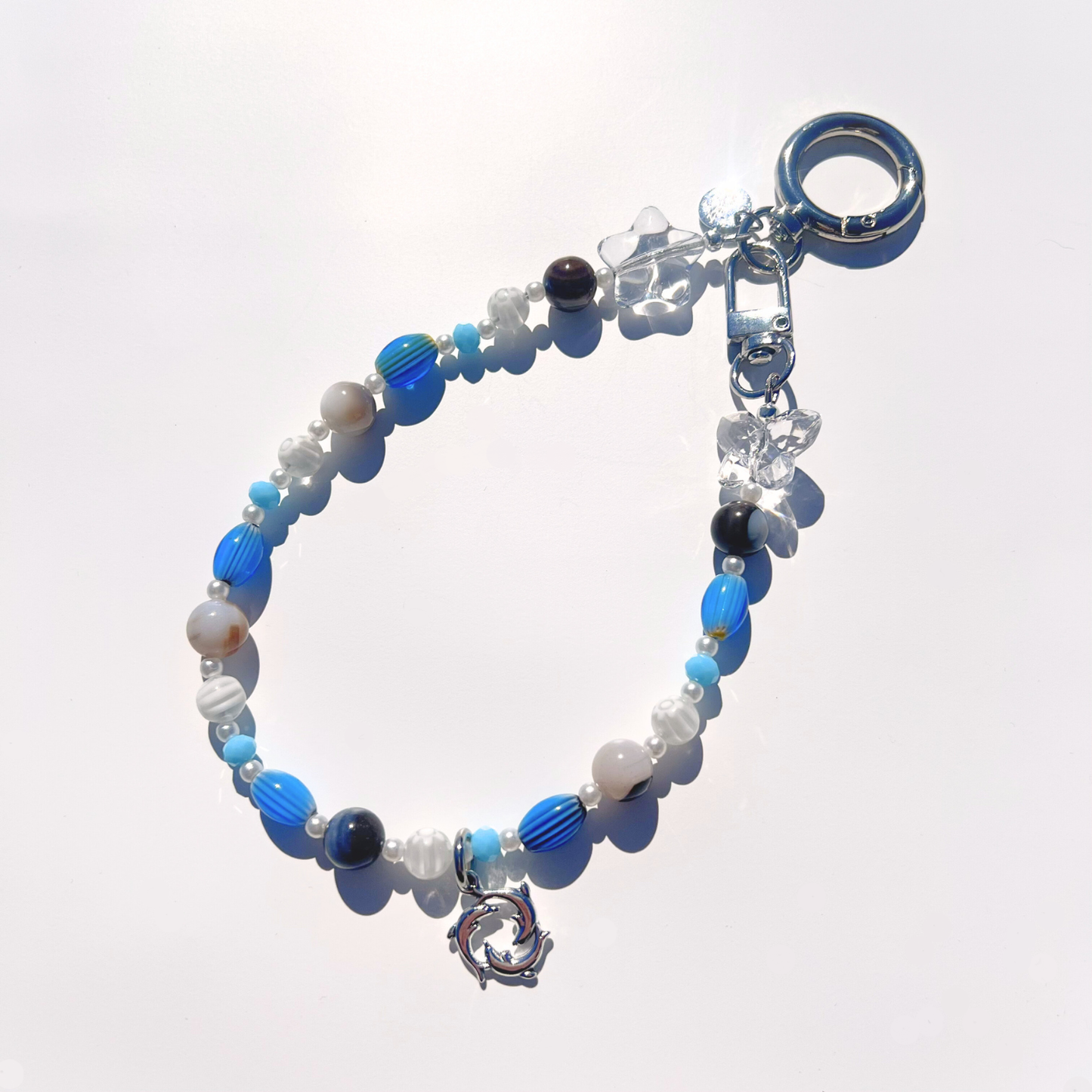 Coastal Muse Marina Blue bag charm featuring mixed blue beads, translucent stars, and silver clasp hardware