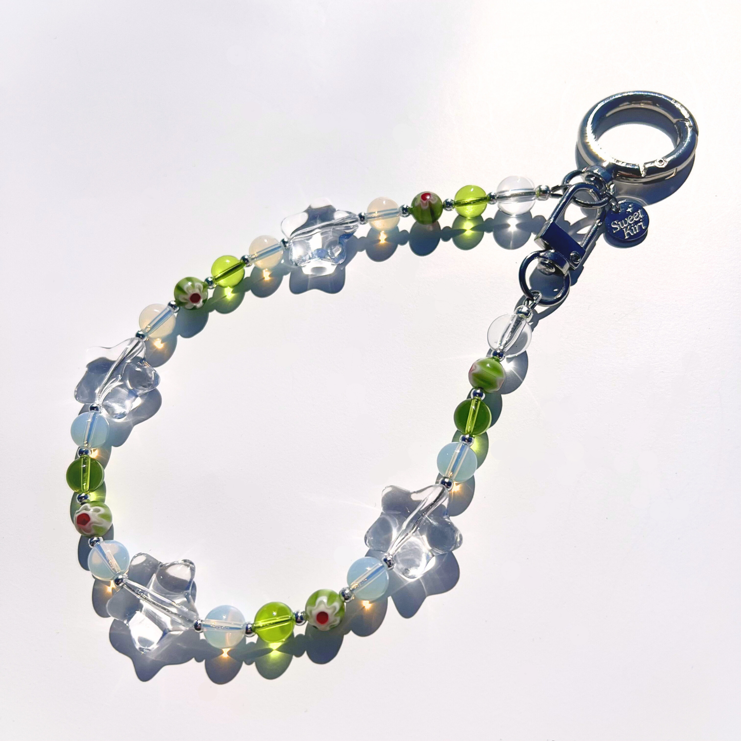 Coastal Muse Tide Pool Green bag charm featuring sea glass green beads, clear glass stars, and silver hardware