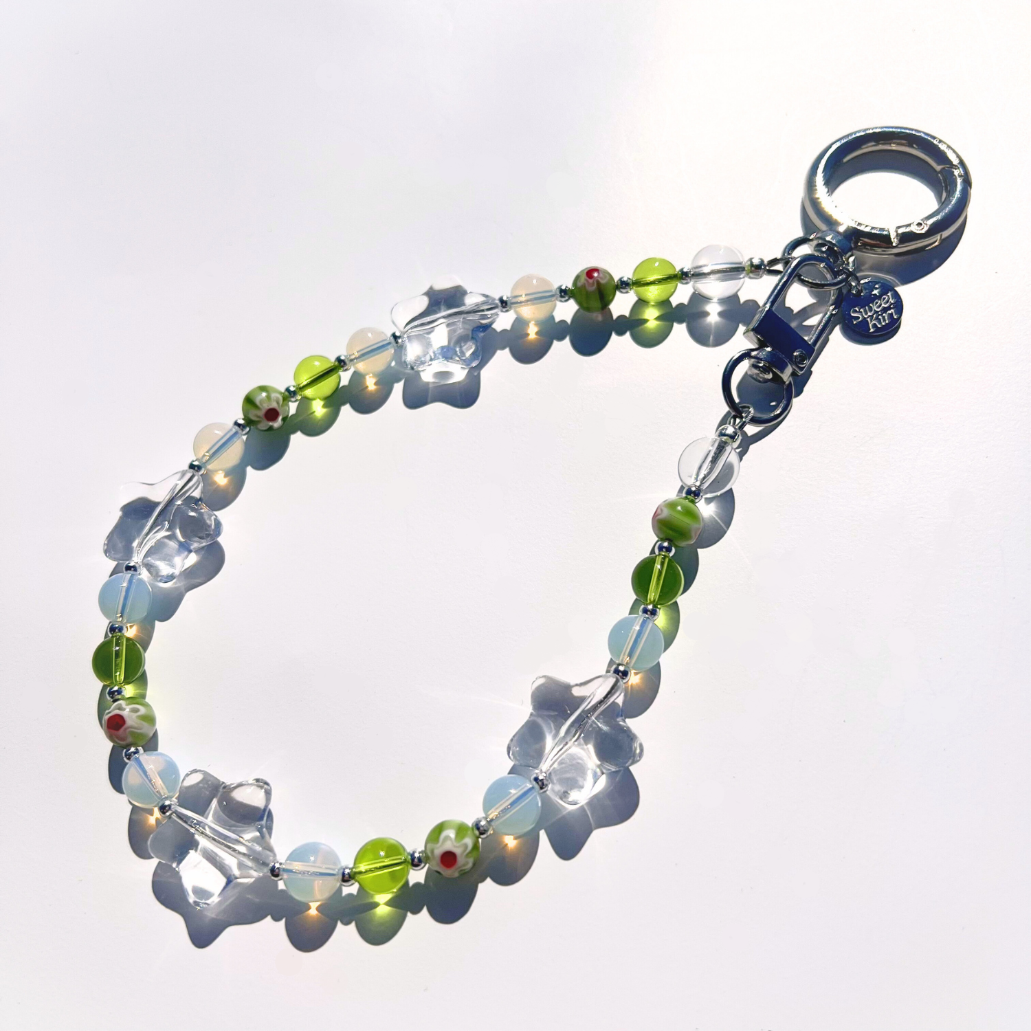 Coastal Muse Tide Pool Green bag charm featuring sea glass green beads, clear glass stars, and silver hardware