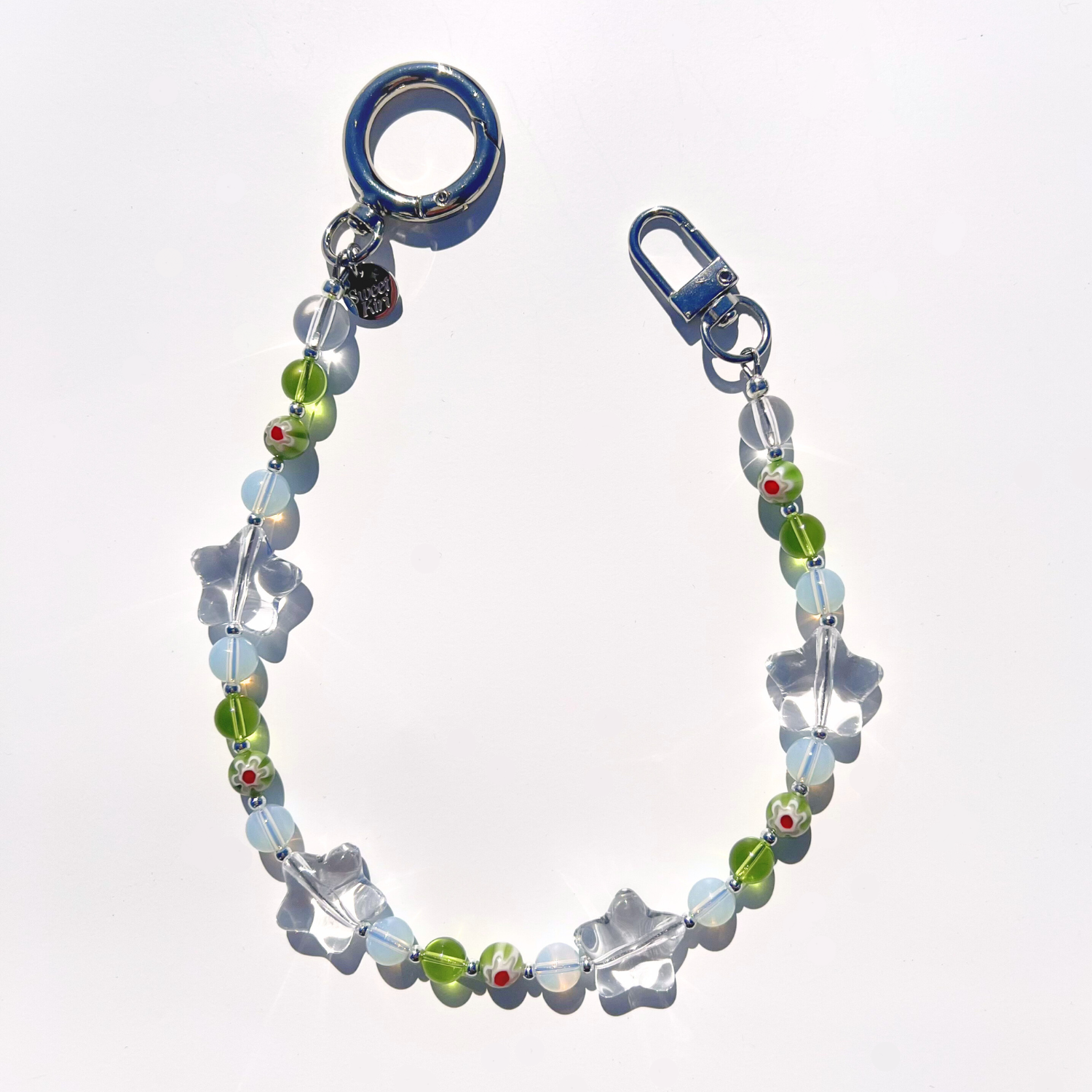 Coastal Muse Tide Pool Green bag charm with green and translucent glass beads, clear star details, and silver clasp hardware