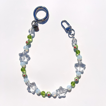 Coastal Muse Tide Pool Green bag charm with green and translucent glass beads, clear star details, and silver clasp hardware