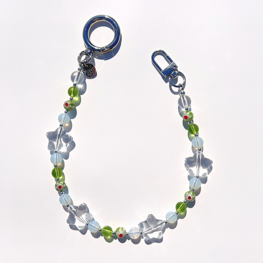 Coastal Muse Tide Pool Green bag charm with green and translucent glass beads, clear star details, and silver clasp hardware