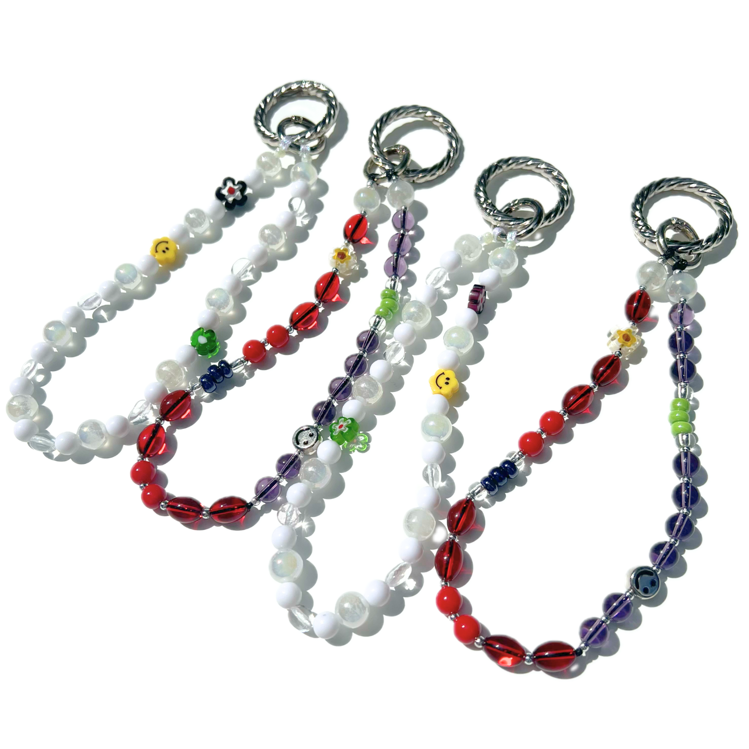 Set of eclectic beaded charms from Sweet Kiri featuring cherry red, purple, and white beads with smiley and floral details, each finished with a silver twist clasp. Handmade with glass, Czech, millefiori, and acrylic beads.