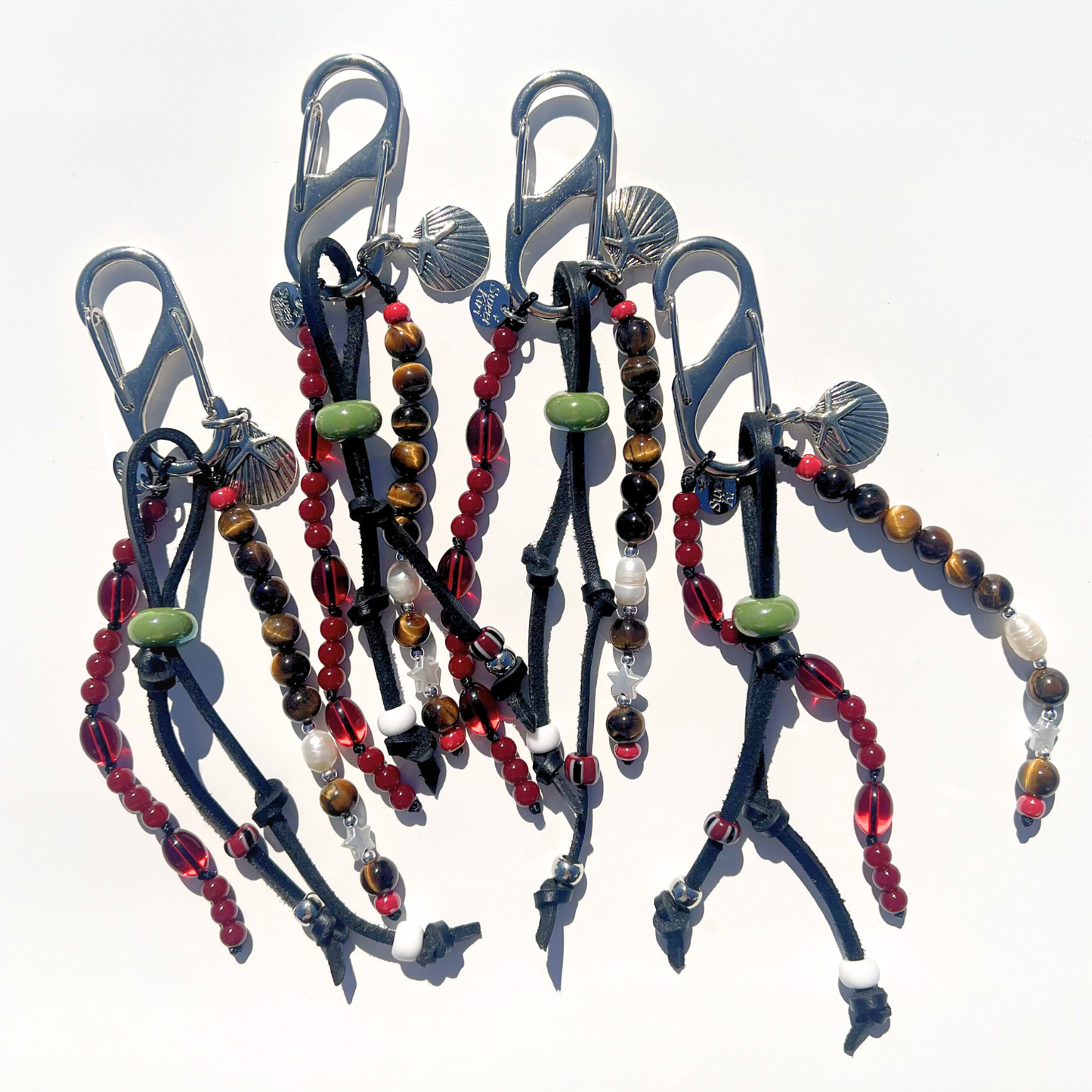 Mariner Relic Tiger Eye & Crimson bag charms featuring tiger eye beads, crimson glass beads, leather cords, and silver starfish shell pendants