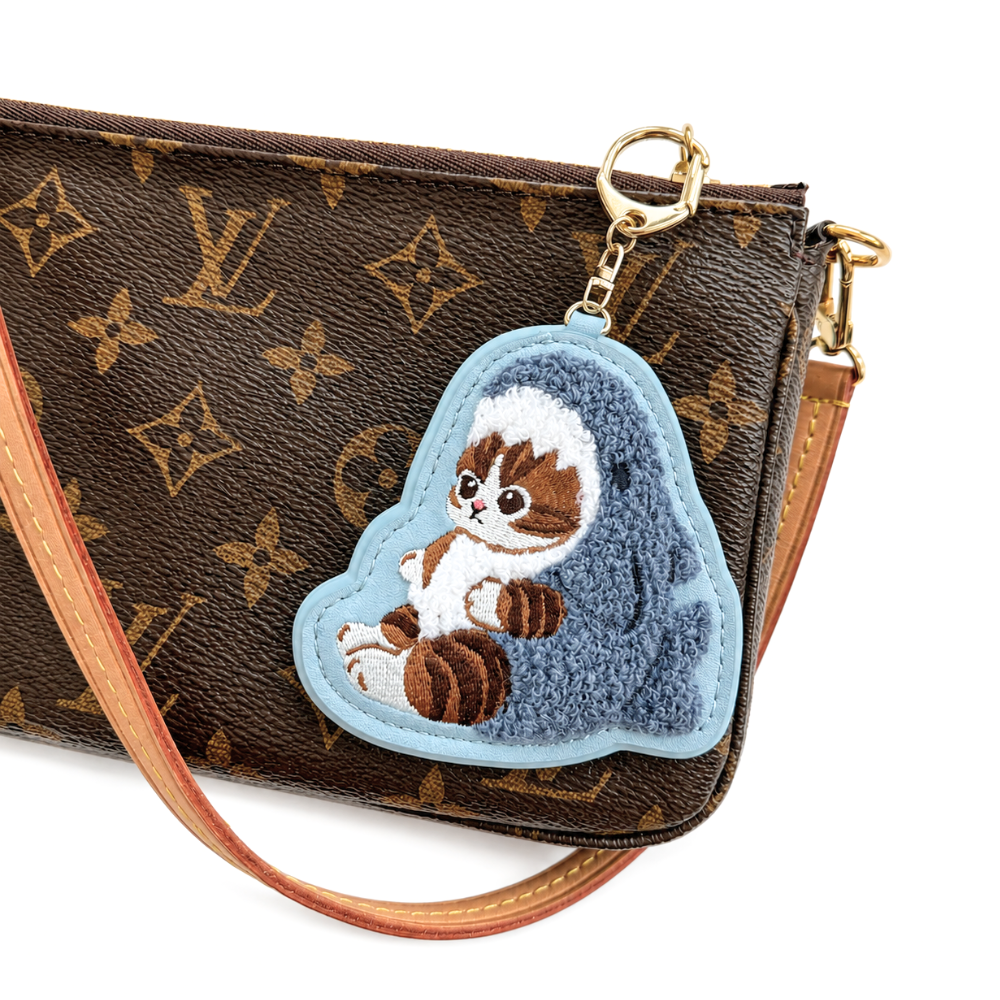 Mofusand shark costume cat embroidered keychain bag charm attached to a handbag with gold-tone clasp