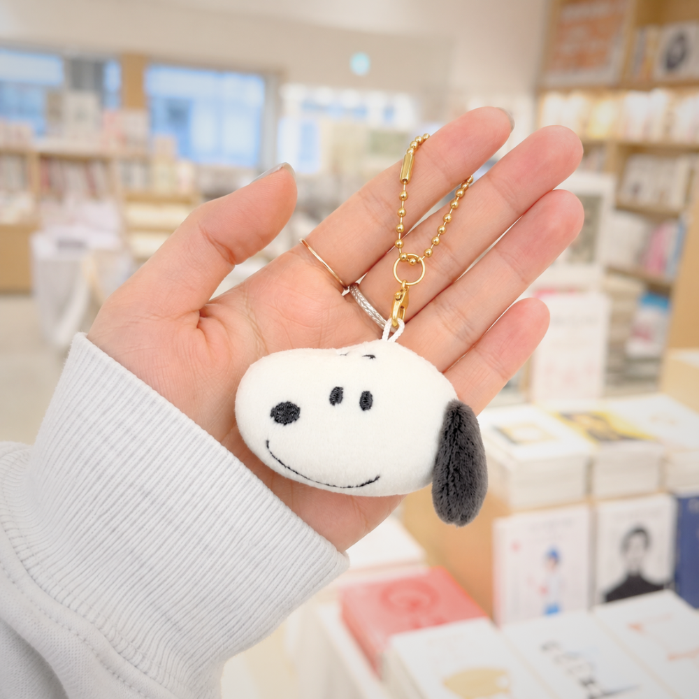 Peanuts Snoopy mini plush keychain bag charm held in hand for size reference
