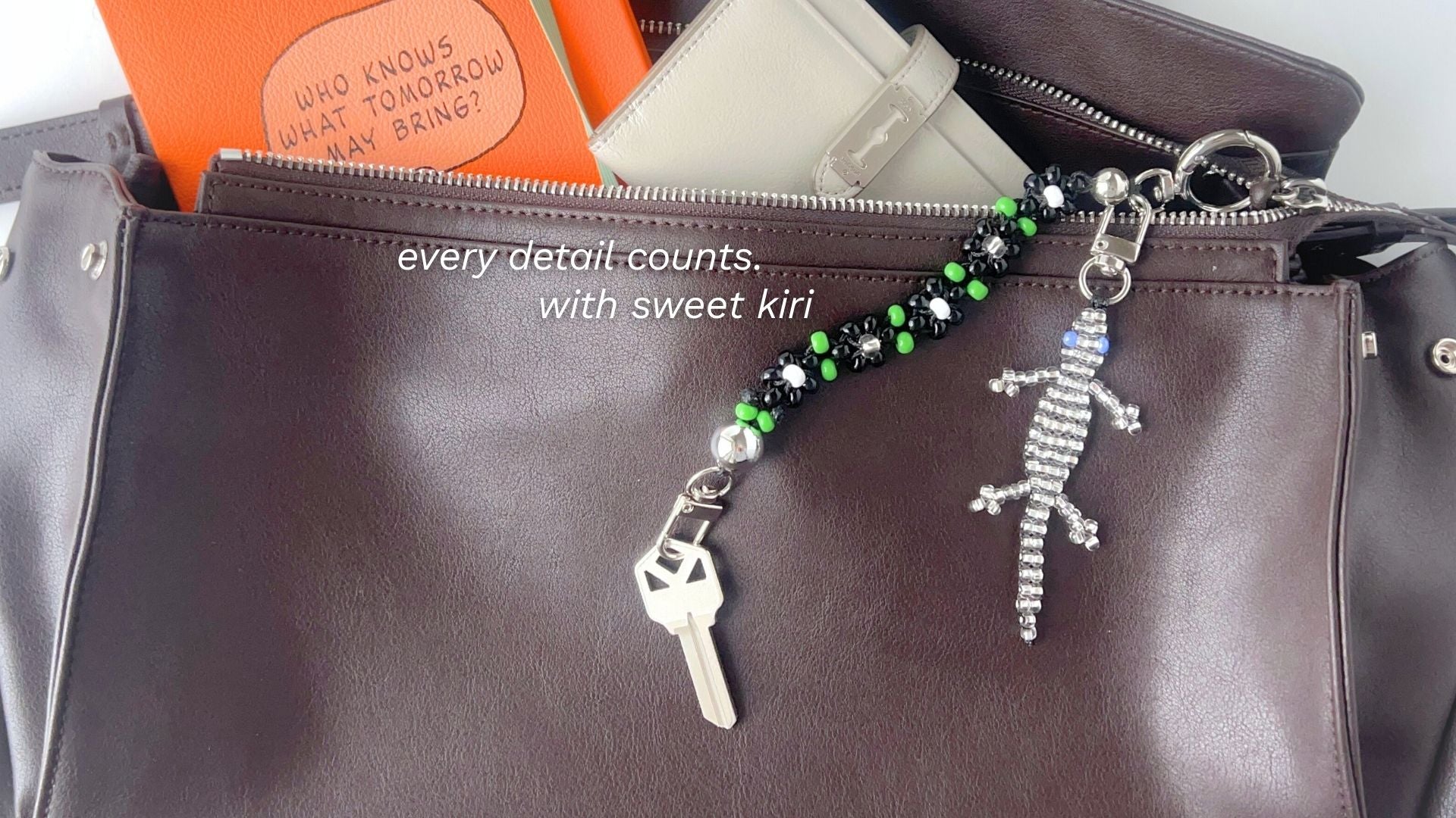 Brown leather bag styled with Sweet Kiri bag charms, featuring beaded details and a silver lizard charm.